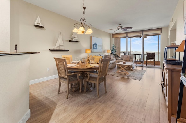 dining room featuring floor to ceiling windows, ceiling fan, light wood-type flooring, and baseboards