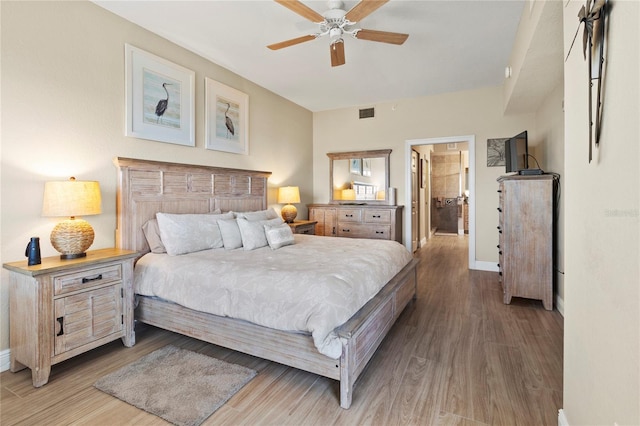 bedroom featuring baseboards, visible vents, wood finished floors, and a ceiling fan