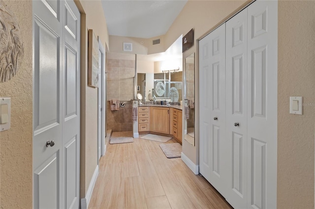 bathroom featuring a stall shower, wood finished floors, and a closet