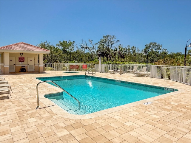 community pool featuring fence and a patio area