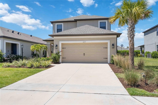 traditional-style house featuring a garage, a shingled roof, concrete driveway, and stucco siding