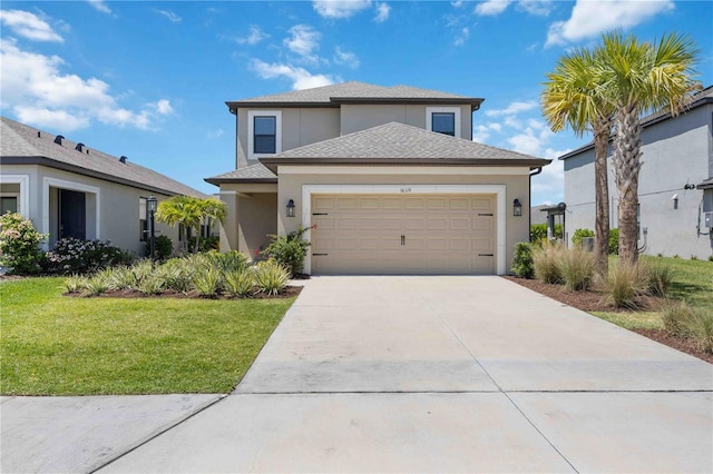 traditional home featuring driveway, an attached garage, a shingled roof, a front yard, and stucco siding