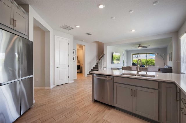 kitchen featuring visible vents, a sink, appliances with stainless steel finishes, and gray cabinets