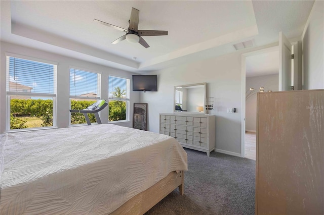 bedroom featuring ceiling fan, a tray ceiling, carpet, baseboards, and visible vents