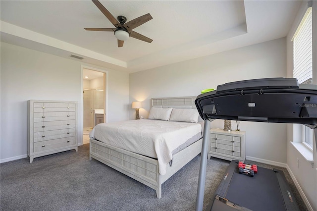 carpeted bedroom featuring ensuite bathroom, baseboards, visible vents, ceiling fan, and a raised ceiling