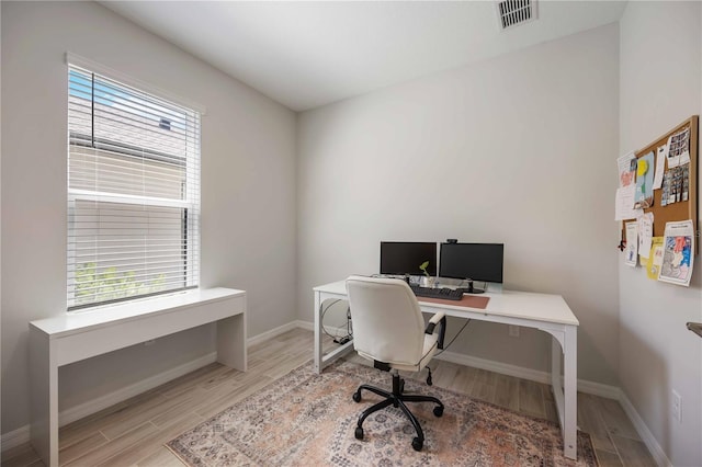 office space featuring visible vents, baseboards, and wood finished floors