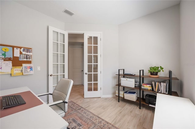 office space featuring wood finished floors, baseboards, french doors, and visible vents