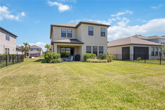 back of property with stucco siding, fence, and a lawn