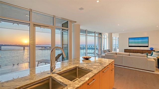 280 Golden Gate Pt Unit 600, Sarasota, FL 34236 - kitchen featuring light stone countertops, a sink, floor to ceiling windows, and wood finished floors