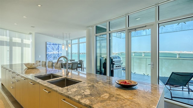 280 Golden Gate Pt Unit 600, Sarasota, FL 34236 - kitchen with a sink, expansive windows, light stone counters, and plenty of natural light