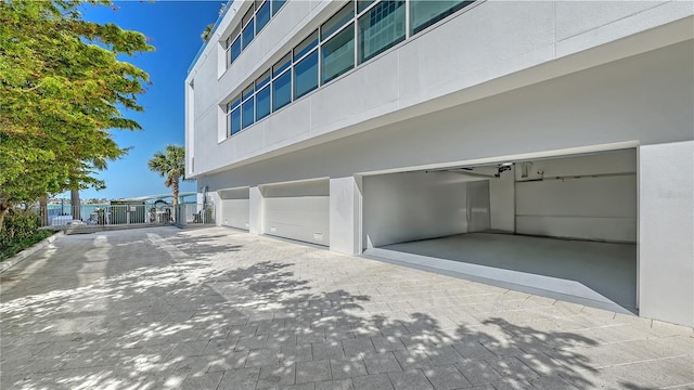 280 Golden Gate Pt Unit 600, Sarasota, FL 34236 - exterior space featuring decorative driveway, stucco siding, fence, and a garage