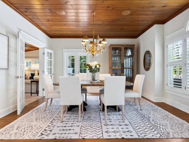 8871 Fishermens Bay Dr, Sarasota, FL 34231 - dining room with wooden ceiling, an inviting chandelier, dark wood-style flooring, ornamental molding, and french doors