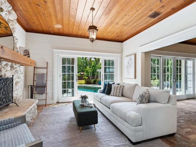 8871 Fishermens Bay Dr, Sarasota, FL 34231 - living area with wood walls, plenty of natural light, brick floor, and wooden ceiling