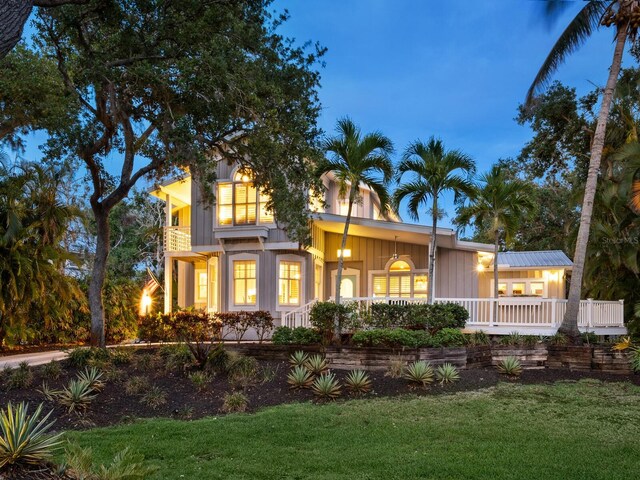 8871 Fishermens Bay Dr, Sarasota, FL 34231 - view of front facade with board and batten siding and a front yard