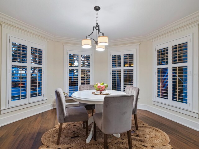 8871 Fishermens Bay Dr, Sarasota, FL 34231 - dining space with ornamental molding, dark wood finished floors, a notable chandelier, and baseboards