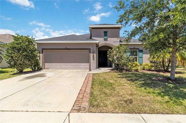 view of front of home featuring a front lawn, stucco siding, driveway, and an attached garage