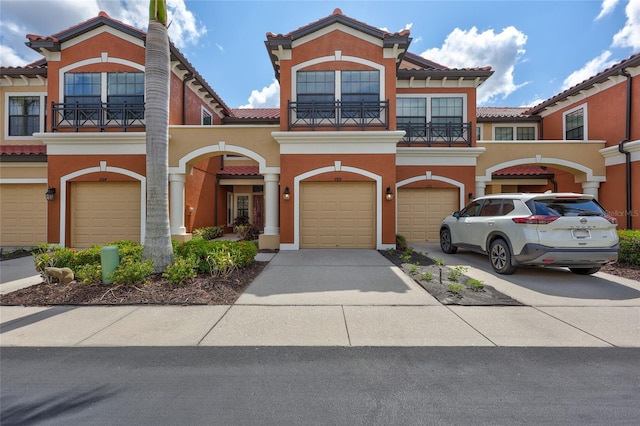 288 Crew Ct, Sarasota, FL 34243 - mediterranean / spanish home with driveway, a tile roof, a balcony, an attached garage, and stucco siding