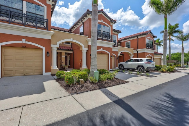 288 Crew Ct, Sarasota, FL 34243 - mediterranean / spanish-style home featuring an attached garage, stucco siding, concrete driveway, a balcony, and a tiled roof