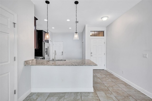 288 Crew Ct, Sarasota, FL 34243 - kitchen with light stone counters, a sink, stainless steel fridge with ice dispenser, a peninsula, and baseboards