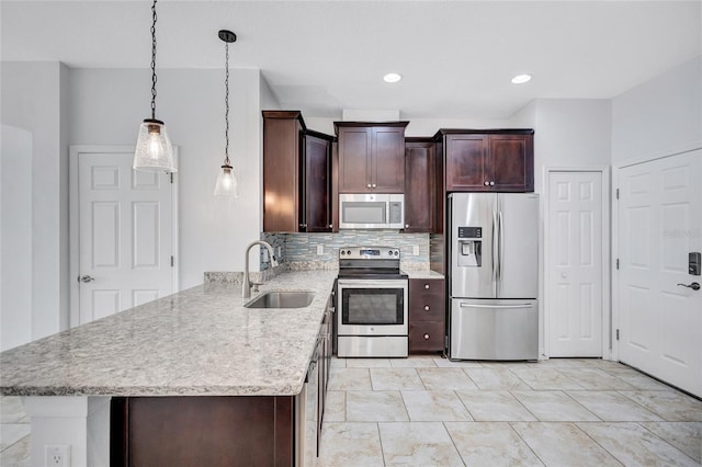 288 Crew Ct, Sarasota, FL 34243 - kitchen with a peninsula, dark brown cabinetry, tasteful backsplash, a sink, and appliances with stainless steel finishes