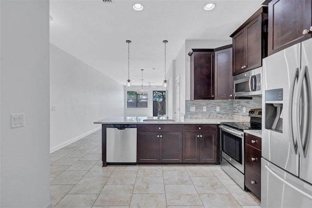 288 Crew Ct, Sarasota, FL 34243 - kitchen with dark brown cabinetry, backsplash, a sink, a peninsula, and stainless steel appliances
