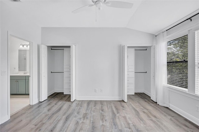 288 Crew Ct, Sarasota, FL 34243 - unfurnished bedroom with baseboards, light wood-type flooring, vaulted ceiling, and two closets