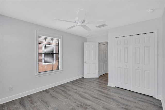 288 Crew Ct, Sarasota, FL 34243 - unfurnished bedroom featuring a ceiling fan, baseboards, wood finished floors, visible vents, and a closet