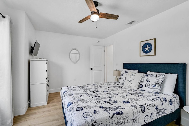 bedroom with light wood-style floors, baseboards, and a ceiling fan