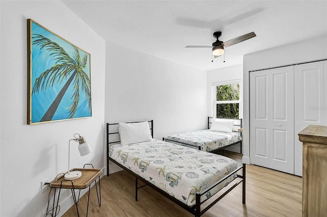 bedroom featuring light wood finished floors, a closet, and a ceiling fan