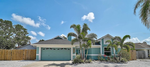 view of front of home featuring stucco siding, fence, an attached garage, and driveway