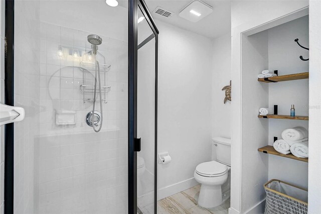 bathroom with a stall shower, toilet, and baseboards