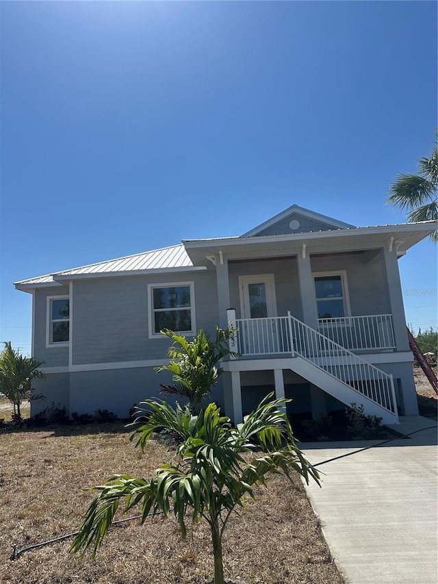 14343 Myakka Ave, Port Charlotte, FL 33953 - view of front facade with metal roof, stairway, and covered porch
