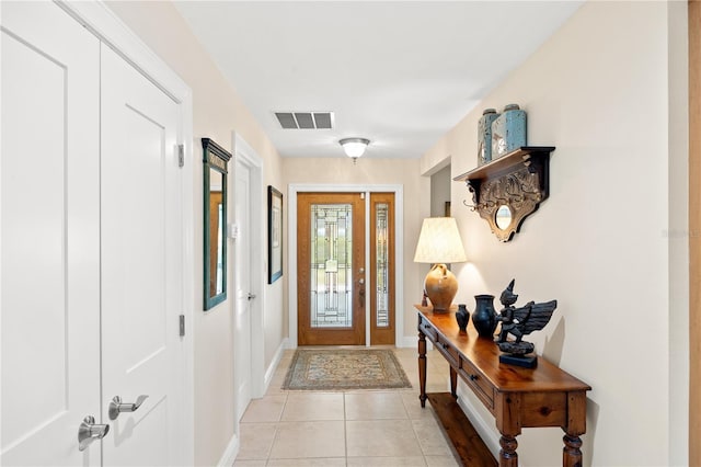 entryway featuring light tile patterned floors, baseboards, and visible vents