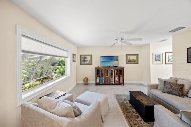 living area featuring visible vents, baseboards, ceiling fan, and light tile patterned flooring