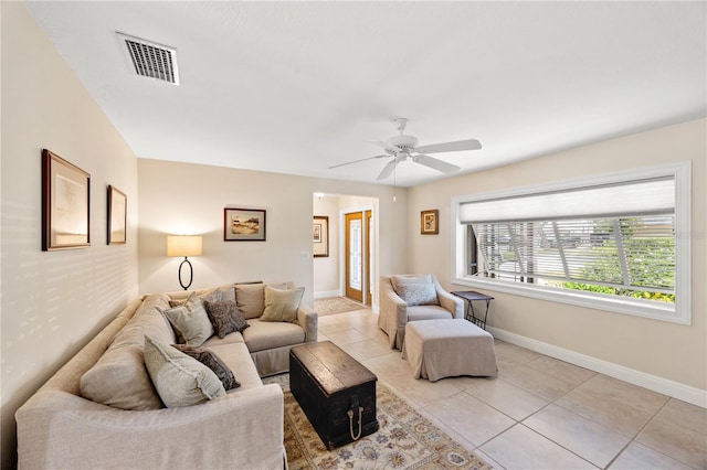 living room with light tile patterned flooring, ceiling fan, visible vents, and baseboards