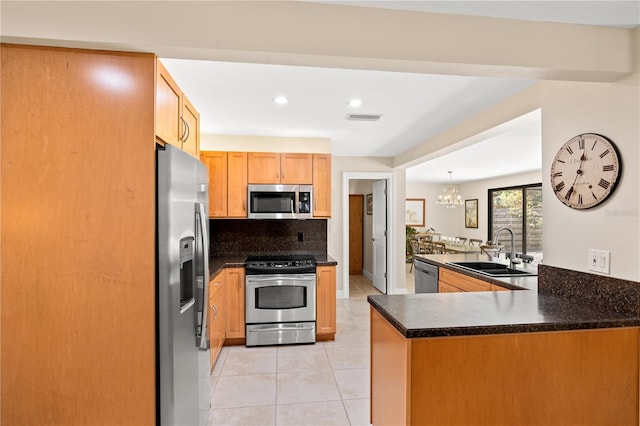 kitchen with light tile patterned flooring, dark countertops, appliances with stainless steel finishes, a sink, and visible vents