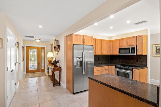 kitchen with backsplash, dark countertops, appliances with stainless steel finishes, baseboards, and light tile patterned flooring