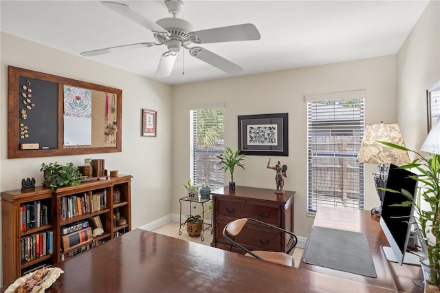 living area featuring baseboards, plenty of natural light, and ceiling fan