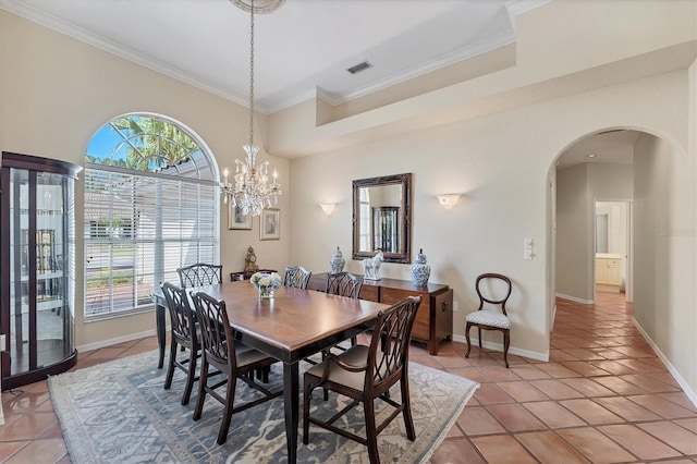 dining area featuring arched walkways, healthy amount of natural light, light tile patterned floors, and ornamental molding