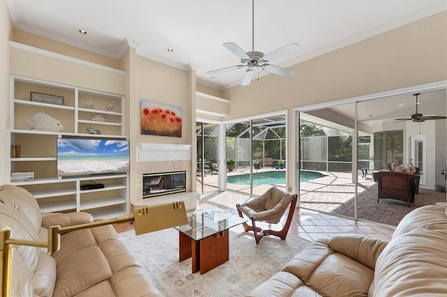living room with a sunroom, ceiling fan, ornamental molding, built in shelves, and recessed lighting
