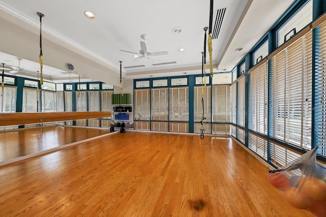 unfurnished room featuring a ceiling fan, wood finished floors, recessed lighting, healthy amount of natural light, and a raised ceiling