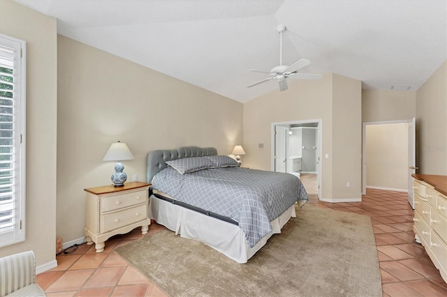 bedroom featuring light tile patterned floors, lofted ceiling, baseboards, connected bathroom, and a ceiling fan
