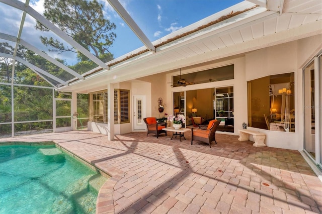 rear view of house featuring a patio, an outdoor pool, glass enclosure, and a ceiling fan