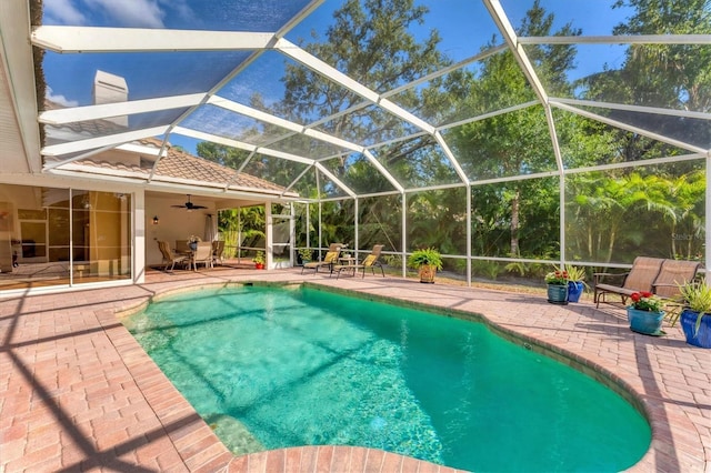 swimming pool featuring a patio area, a ceiling fan, and a lanai