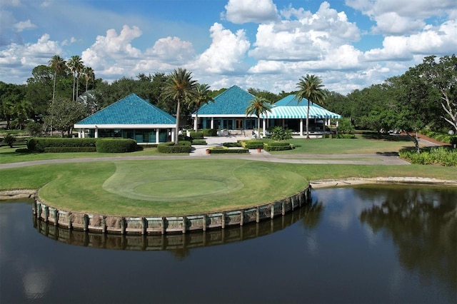 view of home's community with a water view, view of golf course, a lawn, and a putting green