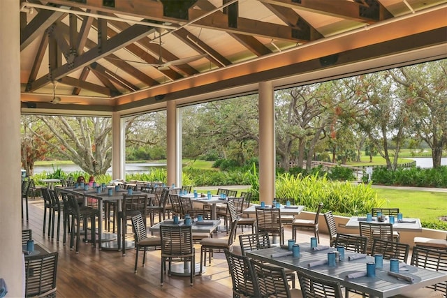 view of patio / terrace featuring outdoor dining space, a gazebo, view of wooded area, and ceiling fan