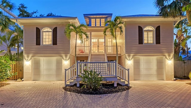 view of front of property with decorative driveway, stairs, and a garage