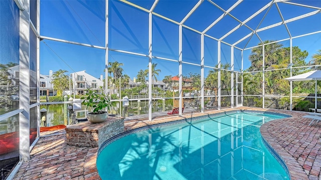 outdoor pool with glass enclosure and a patio area