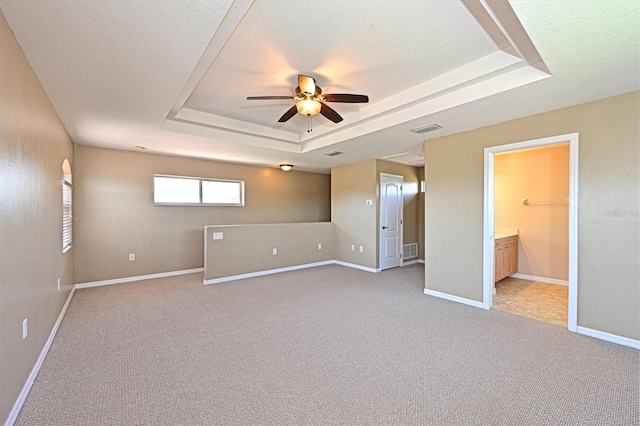 15518 29th St E, Parrish, FL 34219 - unfurnished bedroom with a tray ceiling, light colored carpet, baseboards, and a textured ceiling