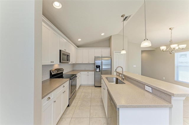 kitchen with tasteful backsplash, appliances with stainless steel finishes, a sink, visible vents, and a center island with sink